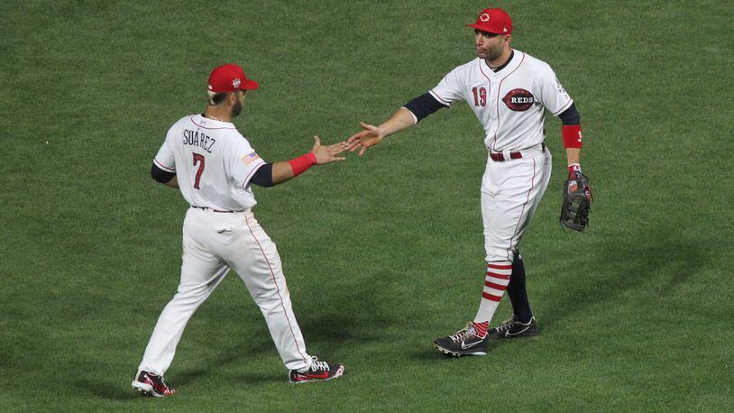 The Reds’ Eugenio Suarez and Joey Votto celebrate after a victory against the White Sox on Monday, July 2, 2018, at Great American Ball Park in Cincinnati. David Jablonski/Staff