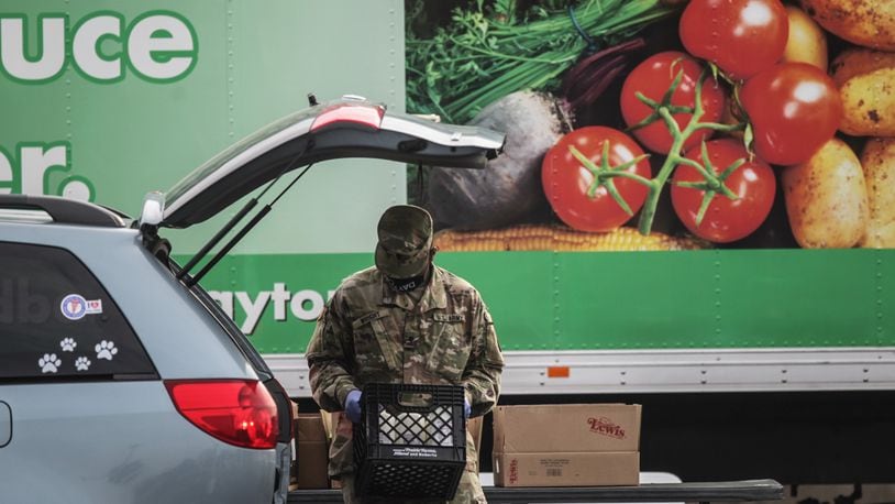 Springfield National Guardsman, Jason Wright loads a car with food at the Living Word Church in Vandalia Wednesday March 10, 2021.
