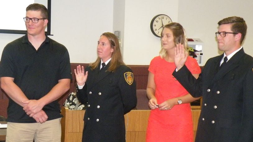 Sarah Wagner and Jeremy Smith were given their oaths as the city s first full-time firefighter/paramedics in the history of the Oxford Fire Department on June 20. At left is Wagner s boyfriend Jason Hudnall, who pinned on her badge while Smith s wife, Molly, pinned on his. CONTRIBUTED