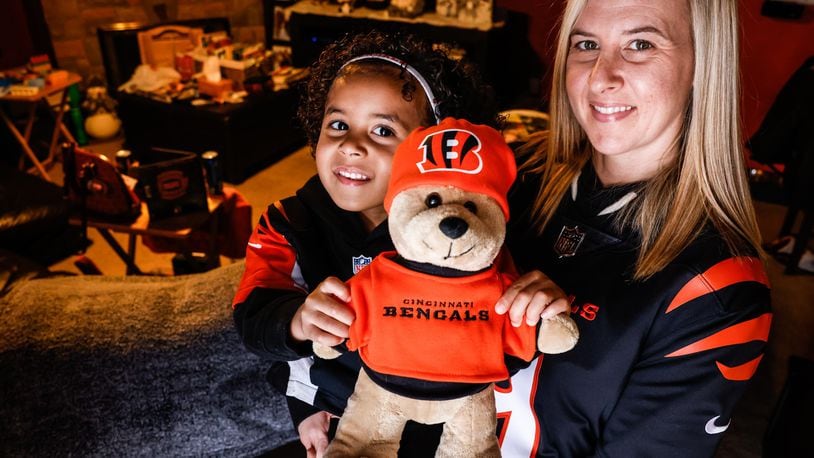 Astrid Whitfield and her daughter Aubriana show off their Cincinnati Bengals fan memorabilia. Whitfield has been a fan since she was 12 years old and followed the team while serving in Korea and Iraq during her years with the U.S. Army. JIM NOELKER/STAFF