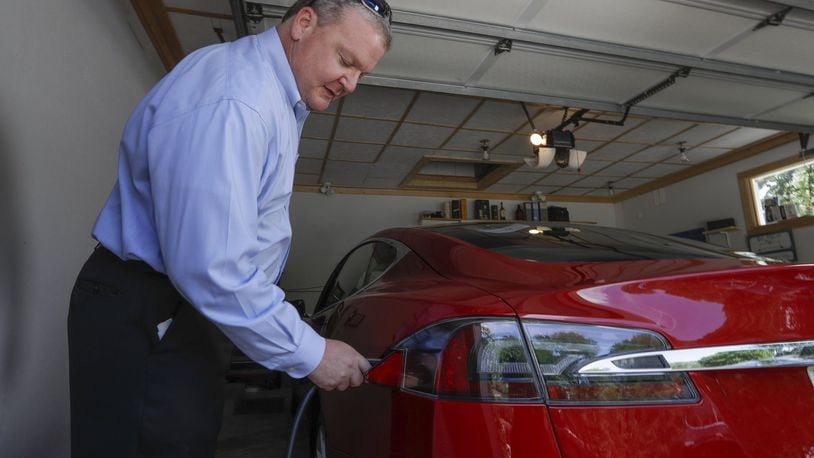 In this Thursday, July 13, 2017, photo, Jeff Solie plugs in his electric Tesla sedan at his home, in New Berlin, Wis. Electric cars are seeing growing support around the world. But there s a problem: There aren t enough places to plug those cars in. The nearest fast-charging Tesla Superchargers are 45 miles away. There are some public charging stations in nearby Milwaukee, at hotels and shopping centers, but Solie relies almost entirely on the charging system he set up in his garage. (AP Photo/Morry Gash)