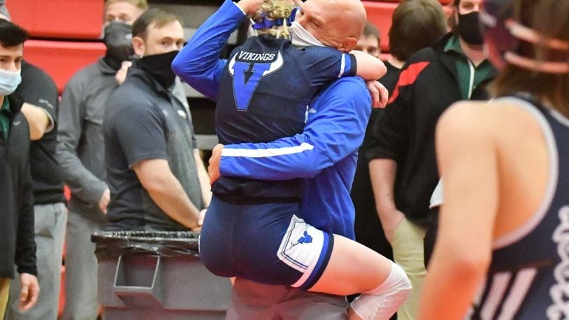 Miami East senior Olivia Shore hugs her coach and father, George Shore, after Olivia became the first female to earn a podium finish in Ohio High School Athletic Association wrestling history. Greg Billing/CONTRIBUTED