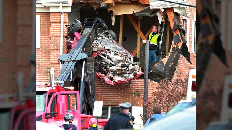 A Porsche is removed from the second story of a building after the convertible went airborne and crashed into the second floor of a New Jersey commercial building early Sunday, killing both of the car's occupants, in Toms River, N.J.