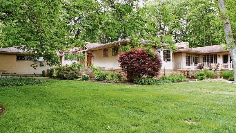 A manicured front lawn gives way to thickly-wooded areas, which provide a natural backdrop and privacy around this renovated and enlarged ranch home, which offers panoramic views of Moraine Country Club Golf Course across the street.