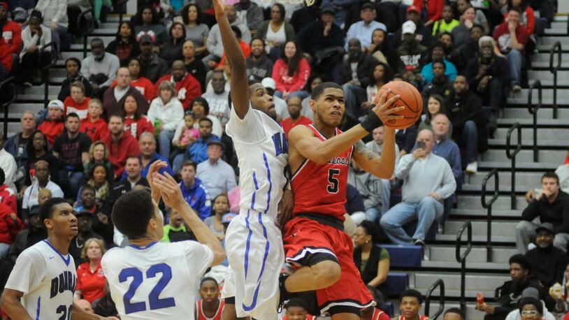 Trotwood’s Amir Foster (with ball) beats Dunbar’s Sh’Mari Jamison to the hoop. Trotwood-Madison defeated Dunbar 83-54 in a boys high school basketball D-II regional final at Fairmont’s Trent Arena last Saturday. MARC PENDLETON / STAFF