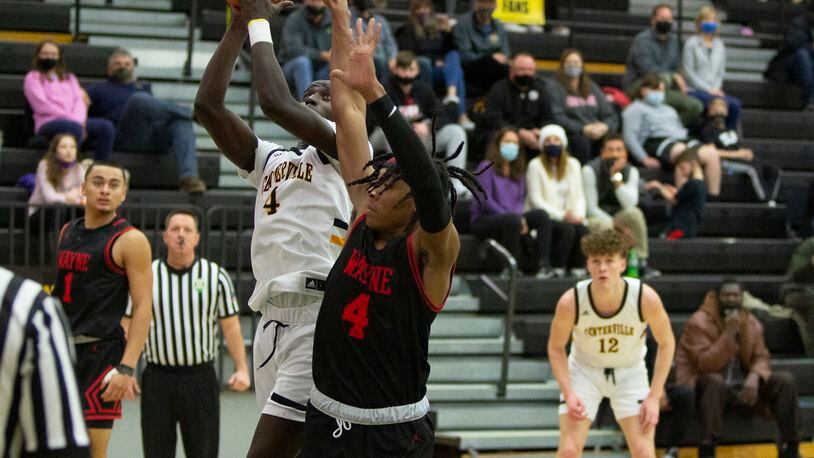 Centerville's Emmanuel Deng puts up a shot against Wayne's Prophet Johnson during a game this season. Jeff Gilbert/CONTRIBUTED