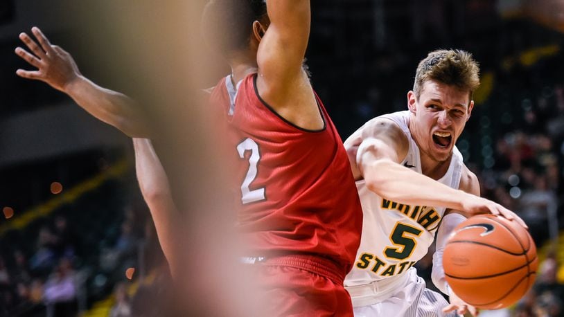 Wright State University’s Mike LaTulip makes a pass under the basket defended by Miami University’s Rod Mills, Jr. during their 89-87 win over Miami Tuesday, Nov. 15 at Wright State University’s Nutter Center in Fairborn. NICK GRAHAM/STAFF