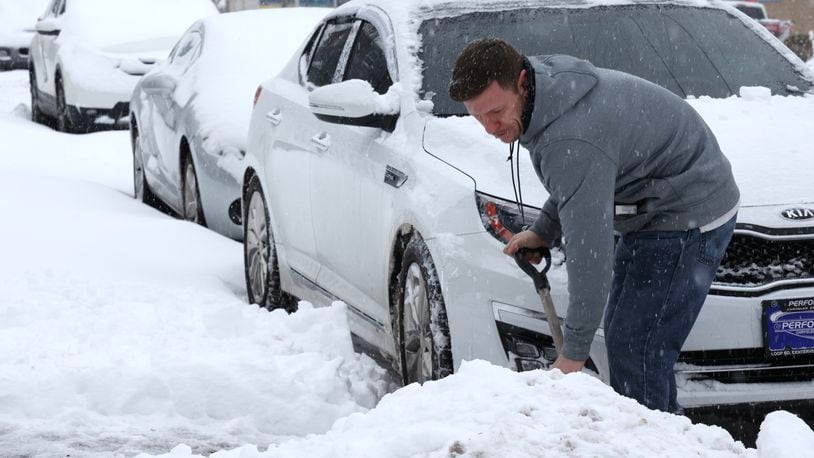 James Thomas shovels his car out of the snow Friday morning along Troy Street in Dayton.