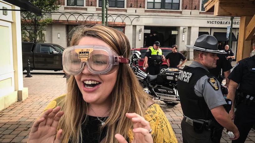 Emma Shales, Clark County Safe Communities coordinator, tries on fatal vision goggles Friday evening at The Greene during the Greene County Safe Communities Coalition's Drive Sober or Get Pulled Over kickoff event.