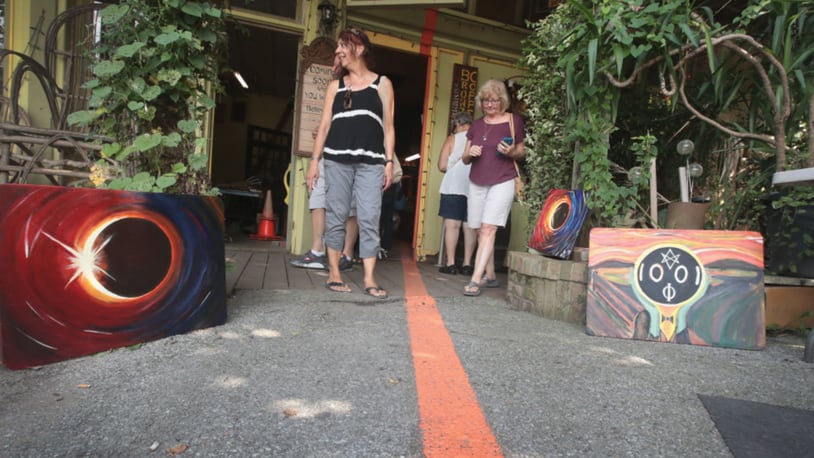 Visitors walk along a line painted through Makanda, Illinois, that represents the anticipated center point of the path of Monday's solar eclipse.