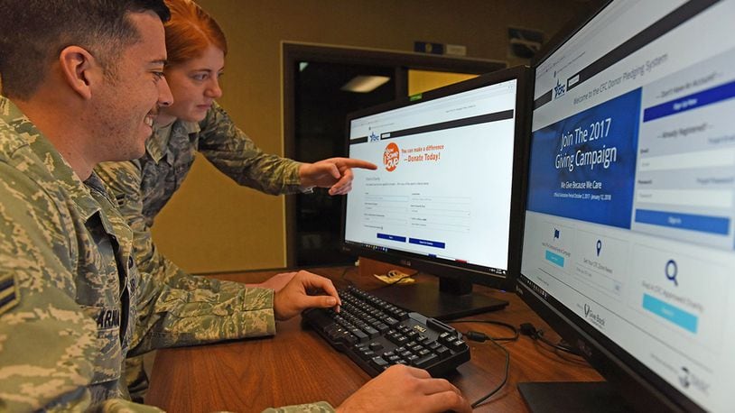 Airman 1st Class Holly Ardern, key worker for the Ohio Combined Federal Campaign, Miami Valley District, at Wright-Patterson Air Force Base, demonstrates features of the new campaign pledging website to Airman 1st Class Jean-Paul Arnaud-Marquez, 88th Air Base Wing Public Affairs, Oct. 16. (U.S. Air Force photo/Michelle Gigante)