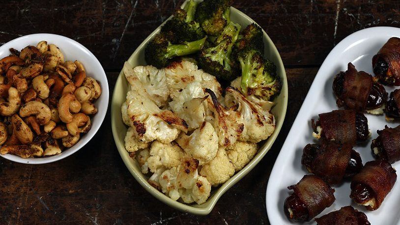 Three of the beer snack choices: beer nuts, from left, garlic and anchovy-roasted cauliflower and broccoli, and cheese-filled, bacon-wrapped dates. (Terrence Antonio James/Chicago Tribune/TNS)