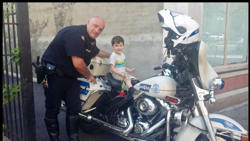 In the days after the Oregon District shootings, Officer Jimmy Howard of the Dayton Police Department’s motor unit poses with Kilo Gibson, who lives in the Oregon District just a block from the shooting. CONTRIBUTED