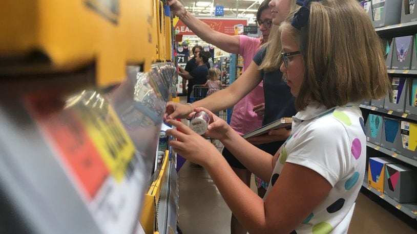Susan Bradley and two of her three daughters, Hope and Lily, of Centerville were shopping early for back-to-school supplies Tuesday. They like to beat the rush on things like folders and use tax-free weekend for clothing. STAFF PHOTO / HOLLY SHIVELY
