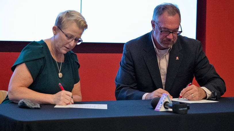 Dr. Sue Edwards, President of Wright State University and Dr. Steve Johnson, President of Sinclair Community College, sign an agreement Thursday to continue the two universities' partnerships. Courtesy of Sinclair Community College.
