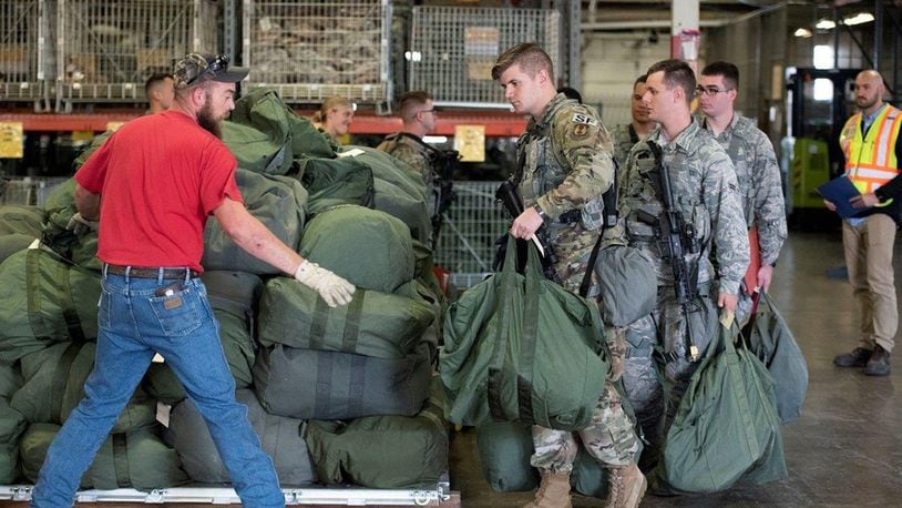 While processing through a deployment line, Airmen from Wright-Patterson Air Force Base place their bags on a pallet for a simulated short-notice deployment during a base readiness assessment at Wright-Patterson Air Force Base Oct. 8. Base readiness assessments are routinely held to practice procedures for responding to emergencies and to show the base’s readiness to rapidly deploy. (U.S. Air Force photo/Michelle Gigante)