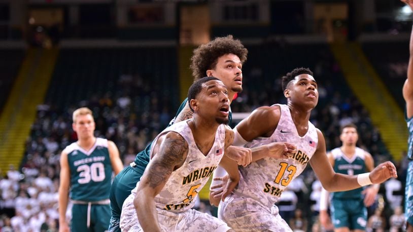 Wright State freshmen Skyelar Potter (left) and Malachi Smith (far right) look to grab a rebound during Saturday’s win over Green Bay. Joseph Craven/CONTRIBUTED