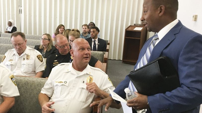 Brookville police Chief Douglas Jerome talks with Michael Colbert, assistant Montgomery County administrator for Development Services, during a commission meeting Tuesday. CHRIS STEWART / STAFF