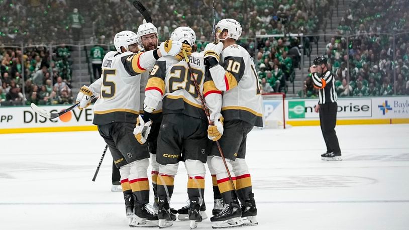 Vegas Golden Knights players surround Noah Hanifin after he scored against the Dallas Stars during the second period in Game 2 of an NHL hockey Stanley Cup first-round playoff series in Dallas, Wednesday, April 24, 2024. (AP Photo/Tony Gutierrez)