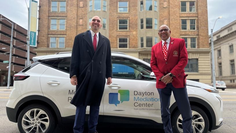 Dayton City Commissioner Matt Joseph and Mayor Jeffrey Mims Jr. show off one of the city's new all electric vehicles outside of City Hall on Friday, Dec. 2, 2022. CORNELIUS FROLIK / STAFF