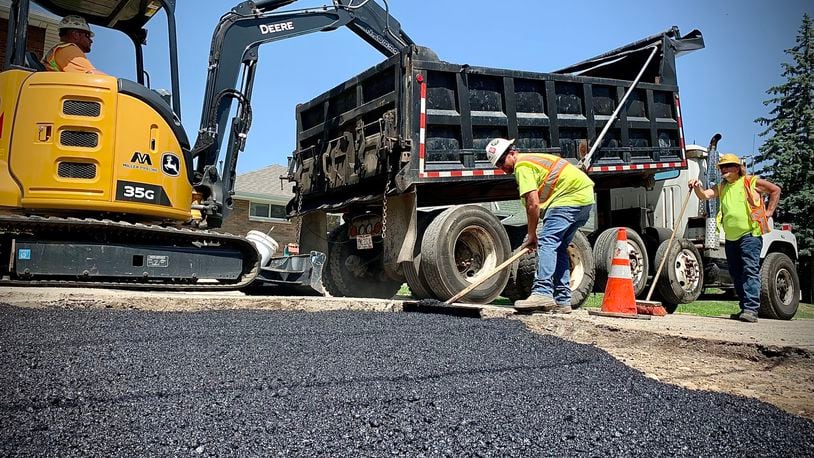 Working with 250 degree asphalt on a 100 degree Wednesday June 15, 2022 makes for hot day for these workers for MIller Pipeline in Dayton. MARSHALL GORBY\STAFF