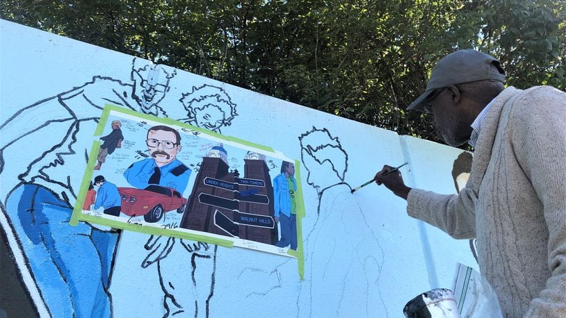 Artist Morris Howard works on the new Steve Whalen memorial mural in southeast Dayton on Friday. CORNELIUS FROLIK / STAFF