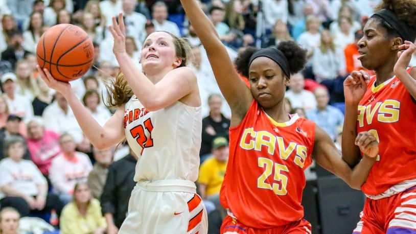 Waynesville High School senior Rachel Murray drives to the hoop against Purcell Marian’s Jaimone Jones (25) and Sha’Dai Hale (32) during a Division III regional final game on Saturday afternoon at Springfield High School. The Spartans won 39-35, advancing to the state tournament for the first time since 2005. CONTRIBUTED PHOTO BY MICHAEL COOPER
