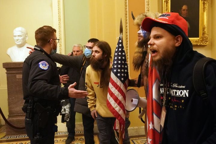 A Capitol Hill police officer confronts people protesting the presidential election results inside the Capitol in Washington on Wednesday, Jan. 6, 2020. (Erin Schaff/The New York Times)
