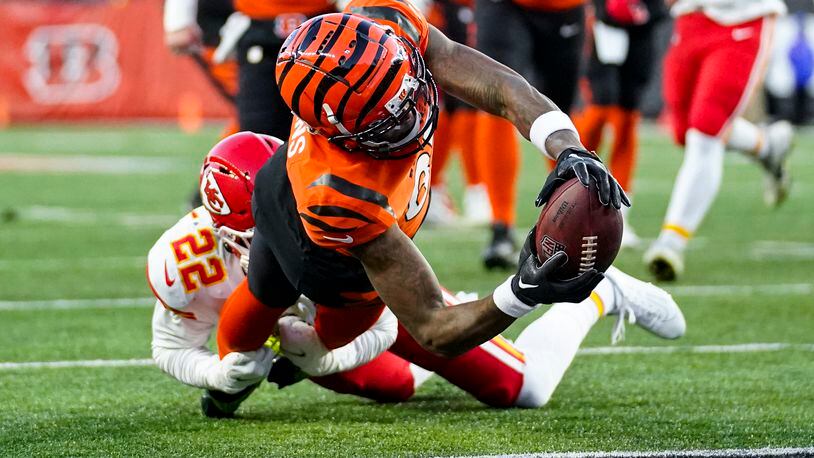 Cincinnati Bengals wide receiver Tee Higgins (85) reaches in for a touchdown as he's tackled by Kansas City Chiefs safety Juan Thornhill (22) in the first half of an NFL football game in Cincinnati, Sunday, Dec. 4, 2022. (AP Photo/Joshua Bickel)