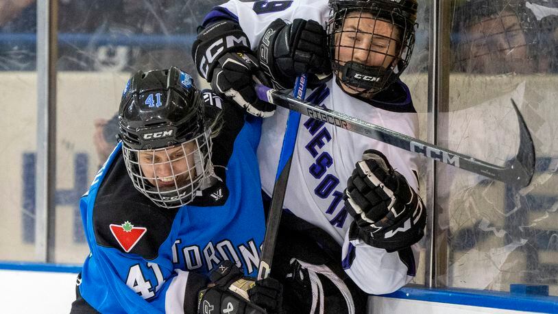 Toronto's Brittany Howard (41) drives Minnesota's Maggie Flaherty (19) into the boards during the second period of a PWHL hockey game in Toronto on Wednesday May 1, 2024. (Frank Gunn/The Canadian Press via AP)