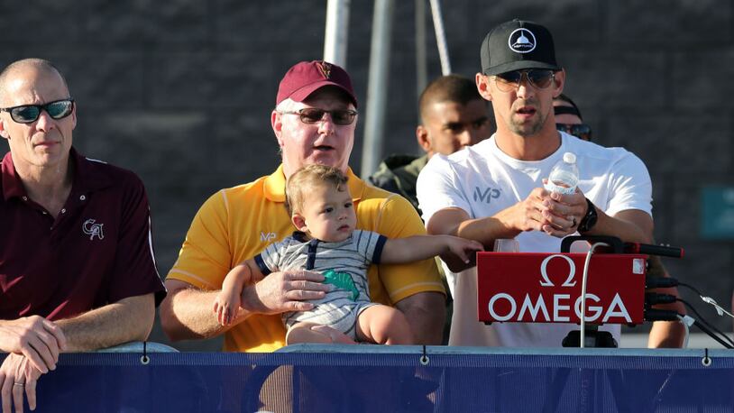 Coach Bob Bowman, Michael Phelps and his son Boomer watch the finals of the men's 400-meter individual medley during last month's Arena Pro Swim Series  in Mesa, Arizona.