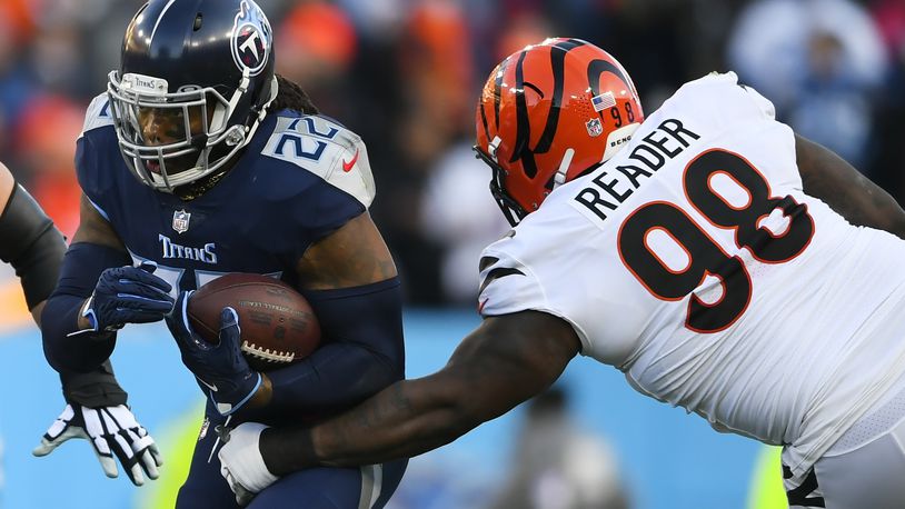 Tennessee Titans running back Derrick Henry (22) runs near Cincinnati Bengals nose tackle D.J. Reader (98) during the first half of an NFL divisional round playoff football game, Saturday, Jan. 22, 2022, in Nashville, Tenn. (AP Photo/John Amis)