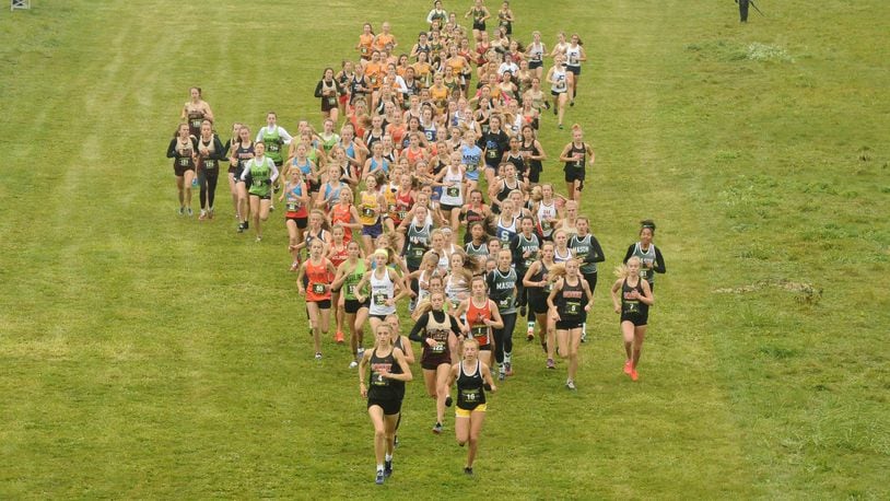Taylor Ewert of Beavercreek (front left) and Emma Bucher of Centerville (front right) lead the Division I field at the regional cross country championships last season at Troy. Contributed / Greg Billing