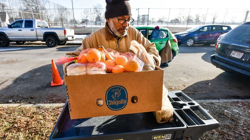 Volunteer Gary Demus loads a cart of donated food into a car for a client at Choice Food Pantry, part of Catholic Social Services of the Miami Valley, on W. Riverview Avenue Friday, Dec. 20 in Dayton. The pantry serves 120-150 people Monday through Friday with fresh produce and recipients get can get baskets once a month including dry goods, dairy, bread and meat items according to Choice Food Pantry Coordinator Ash Cummings. Most of the food comes from Dayton Food Bank. NICK GRAHAM/STAFF