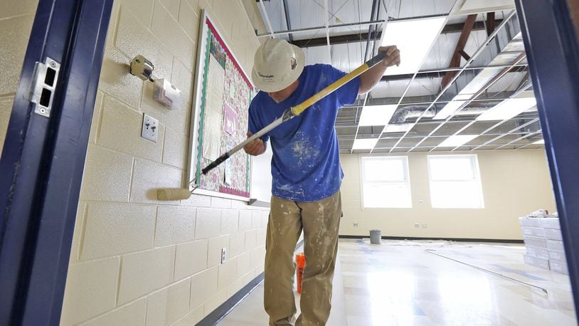 Brian Fenton paints a classroom before new ceiling tile is installed in Brookville High School after the building was damaged by the Memorial Day tornado. The district is getting ready for an expected school opening date of August 15. TY GREENLEES / STAFF