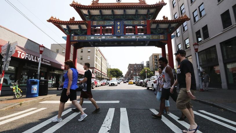 The tour group heads past the Chinese Gate on King Street dedicated a decade ago. King Street is considered the business heart of Chinatown International District (says Don Wong) and the gate a welcoming symbol. (Alan Berner/The Seattle Times/TNS)