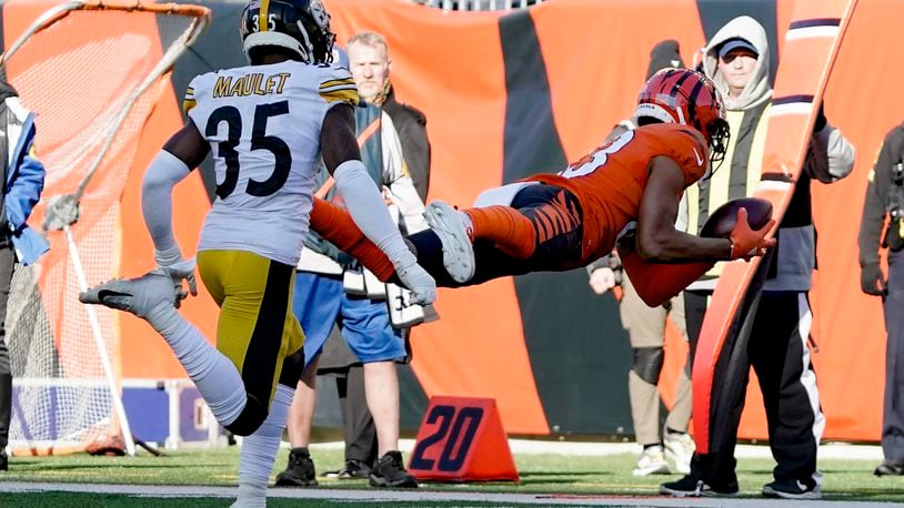 Cincinnati Bengals wide receiver Tyler Boyd (83) makes a diving catch past Pittsburgh Steelers cornerback Arthur Maulet (35) during the first half of an NFL football game, Sunday, Nov. 28, 2021, in Cincinnati. (AP Photo/Jeff Dean)