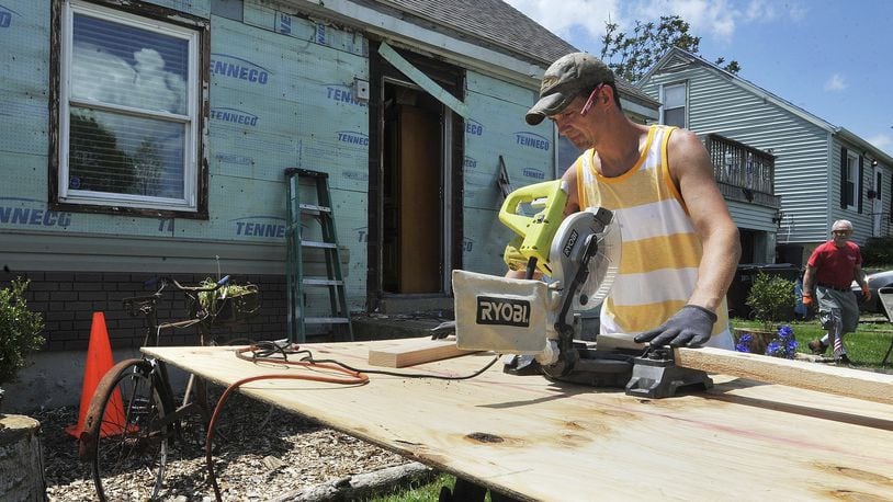 Homeowner Sam Anderson, helps members of the Southern Ohio District Brethren Disater Ministries repair his home on Loretta Drive in Harrison Township. The home was destroyed by tornadoes last year. MARSHALL GORBYSTAFF