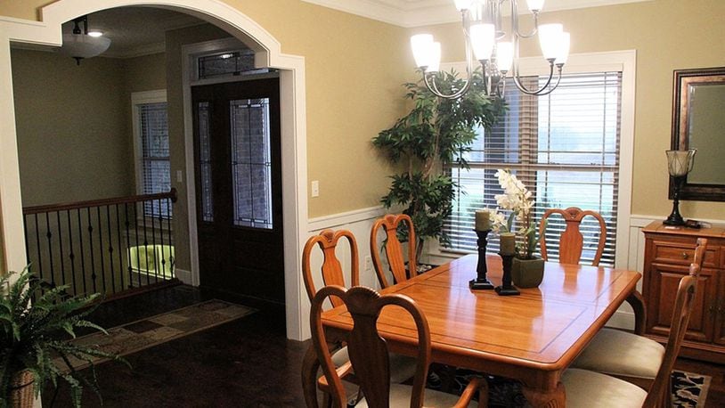 Wide casings frame the openings into the dining room, where wainscoting adds an elegant touch.