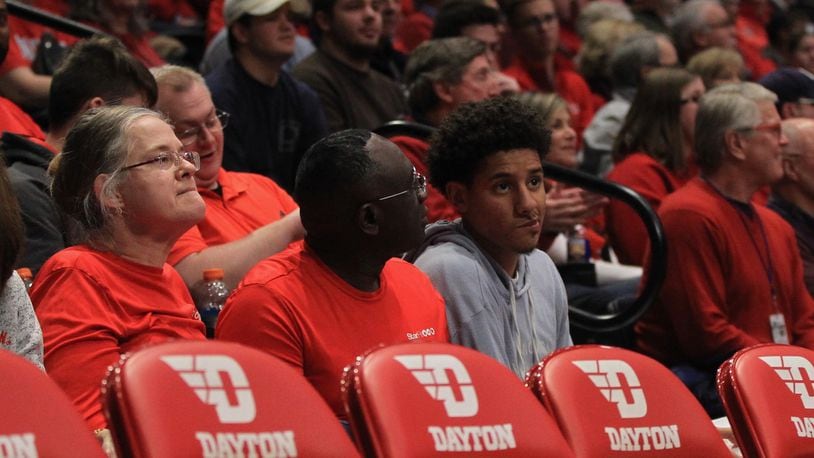 Zimife Nwokeji, right, sits behind the Dayton bench on Saturday, Dec. 14, 2019, at UD Arena.