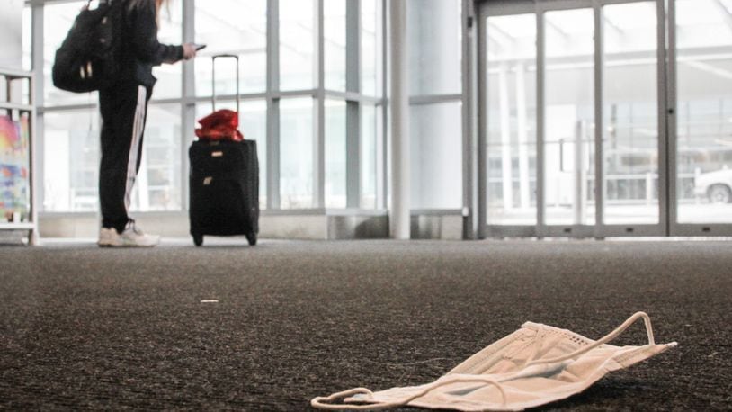A discarded mask lay on the floor at Dayton International Airport. JIM NOELKER/STAFF