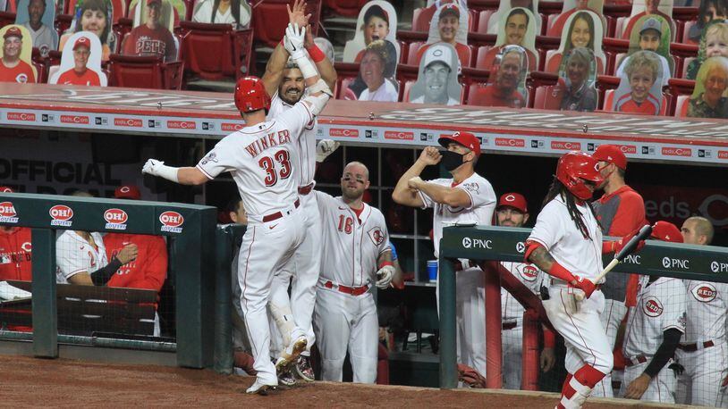 Jesse Winker and Eugenio Suarez, of the Reds, celebrate after Winker's home run against the Brewers on Wednesday, Sept. 23, 2020, at Great American Ball Park in Cincinnati. David Jablonski/Staff