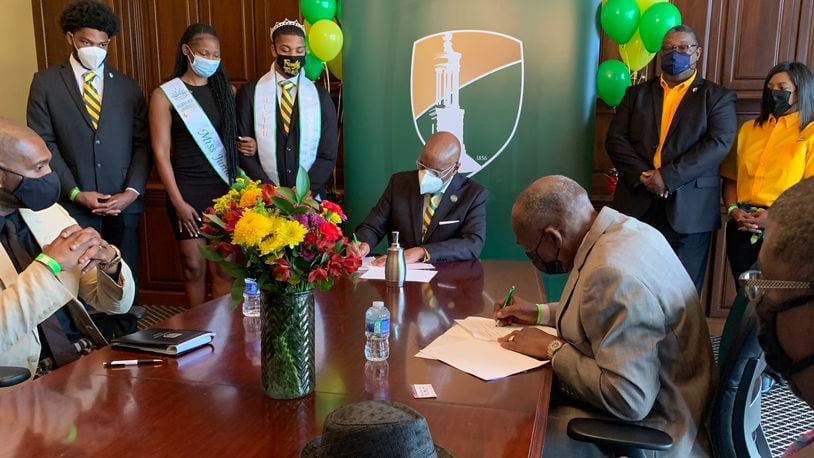 Wilberforce University president and the director of the Dayton Job Corps sign an agreement allowing students of both institutions to take classes at each.
