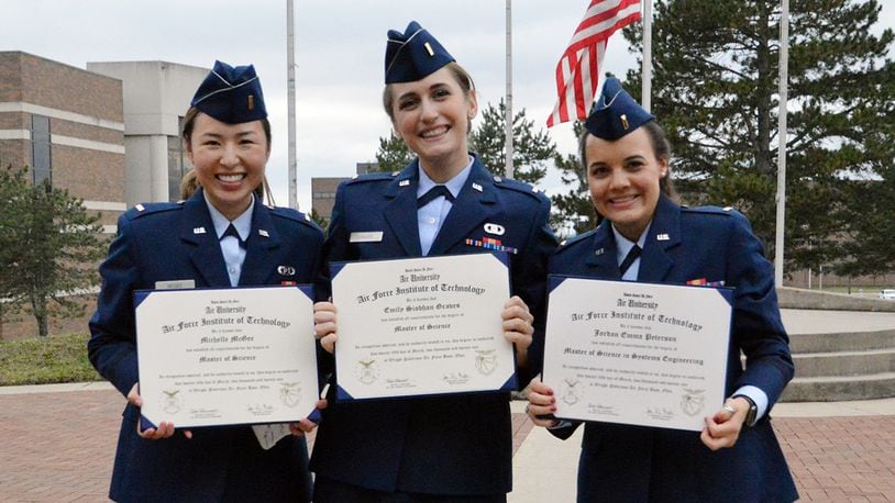 Second Lts. Michelle McGee, Emily Graves and Jordan Peterson display their Master of Science degrees following the March 25 commencement ceremony at the Air Force Institute of Technology. U.S. AIR FORCE PHOTO/KATIE SCOTT