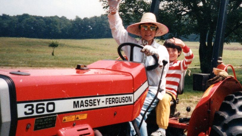 Dr. Ruby Yuan-Ling loved riding her tractor in her straw hat on her Beavercreek Twp. farm; pictured here, with grandson Benjamin Black (Stella’s son, now an adult) riding on back. CONTRIBUTED