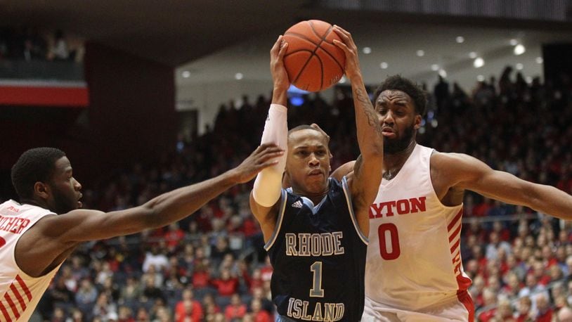 Rhode Island's Fatts Russell drives to the basket between Dayton's Jalen Crutcher, left, and Josh Cunningham in the first half on Friday, March 1, 2019, at UD Arena.