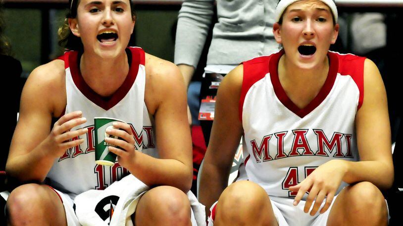 Miami’s Courtney Osborn (left) and Kirsten Olowinski shout encouragement from the bench during the RedHawks’ 84-71 loss to visiting Kentucky on Nov. 14, 2010. JOURNAL-NEWS FILE PHOTO