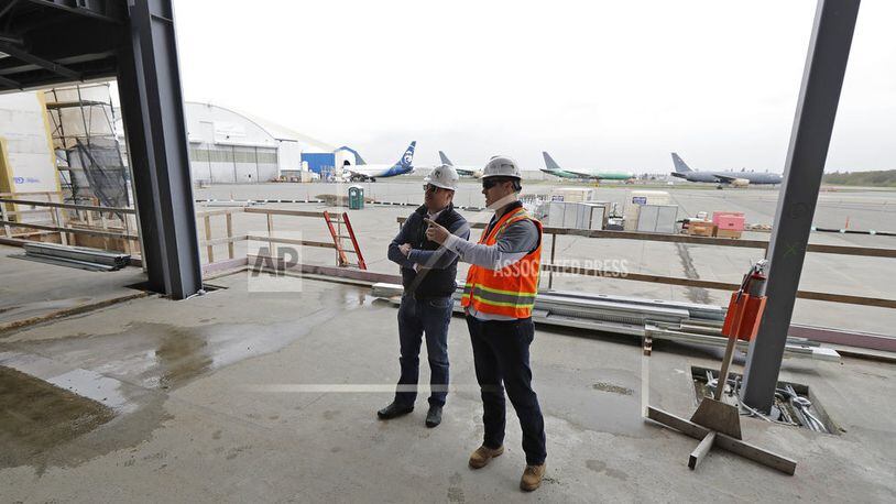In this April 11, 2018 photo, Brett Smith, CEO of Propeller Airports, left, talks with project engineer Todd Raynes, right, inside the privately-run commercial U.S. airport terminal Smith's company is building at Paine Field in Everett, Wash. Propeller Airports sold $50 million in bonds earlier this year to finance the construction, according to data obtained by The Associated Press. The terminal has commitments from Alaska Airlines, Southwest Airlines and United Airlines for up to 24 daily flights, mostly to destinations in the West and Midwest. (AP Photo/Ted S. Warren)