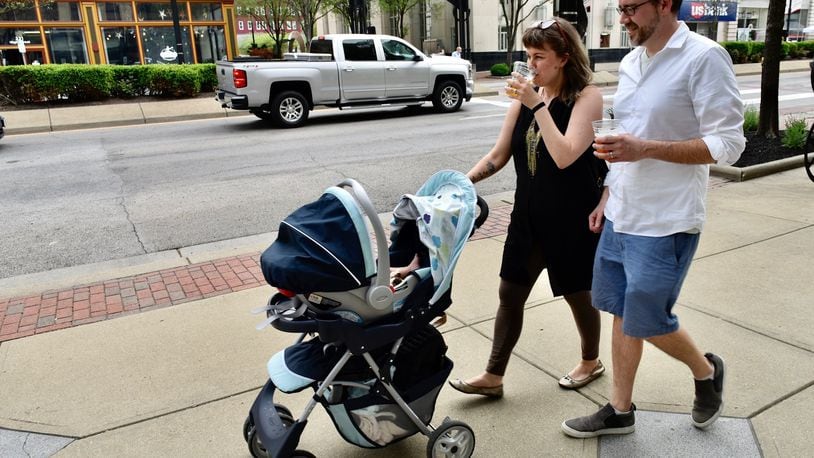 The city of Xenia could have a Designated Outdoor Refreshment Area (DORA) as early as this spring. Many other cities in the region have them, including Dayton, Middletown and Hamilton. Jennifer Acus-Smith and Stephen Smith walk down the sidewalk on High Street on the first day of Hamilton's DORA on May 3, 2020. NICK GRAHAM/STAFF