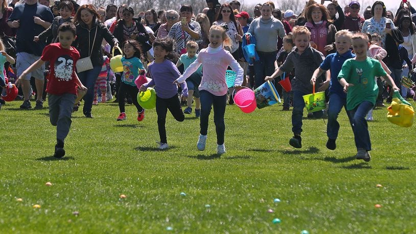 Hundreds of children and their parents scramble across the driving range at Young's Jersey Dairy as they participate in the 37th annual Easter Egg Hunt at Young's Dairy Sunday. The Dairy started with a few dozen eggs and a couple children has turned into a monumental event where they color 10,000 hard boiled eggs each year for hundreds of children. BILL LACKEY/STAFF